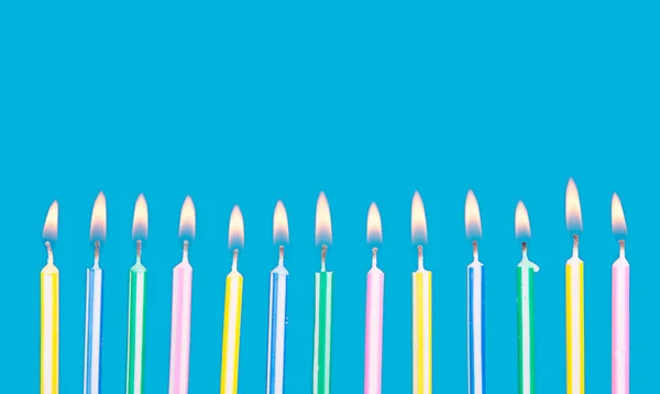 Velas de cumpleaños en una fila con llamas — Foto de Stock