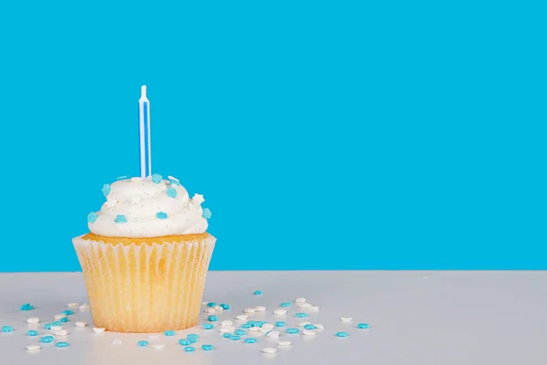 Cupcake único com vela azul e polvilhas — Fotografia de Stock