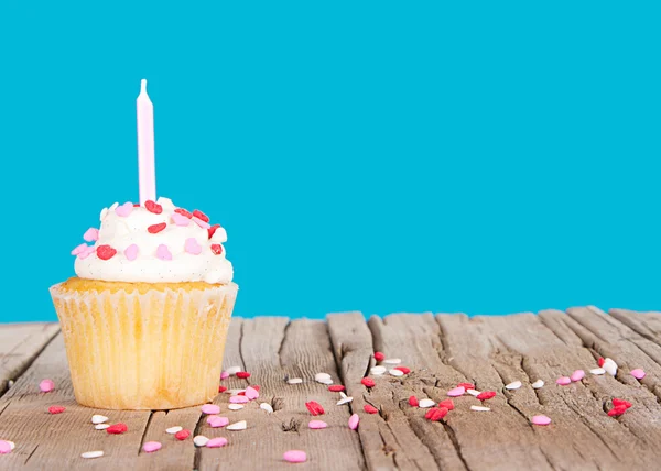 Cupcake com vela rosa e polvilhas de coração — Fotografia de Stock