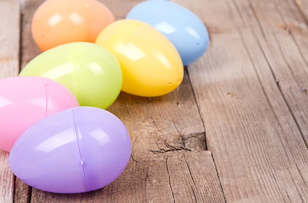 Plastic easter eggs on wooden plank — Stock Photo, Image