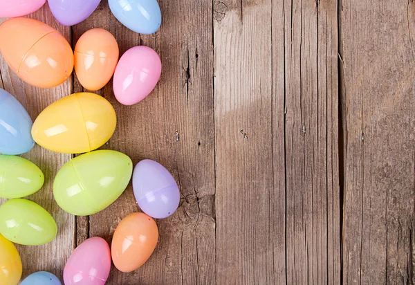 Plastic easter eggs on wooden plank — Stock Photo, Image