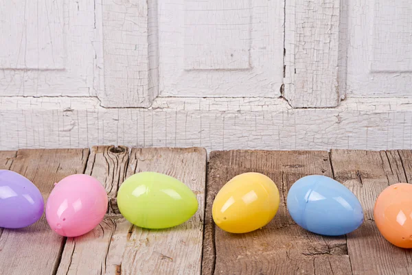 Plastic easter eggs on wooden plank — Stock Photo, Image