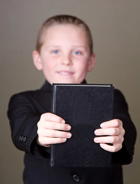 Boy segurando livro para fora — Fotografia de Stock