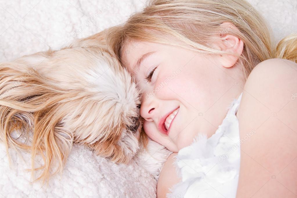 girl laying with shih tzu dog