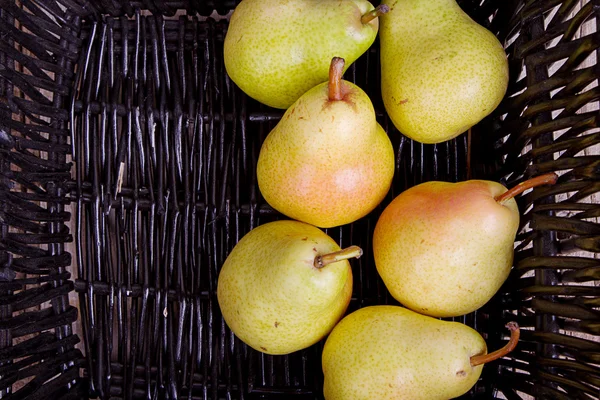 Pears in a black basket — Stock Photo, Image