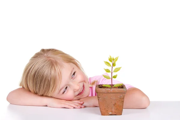 Kind mit Pflanze lächelt — Stockfoto