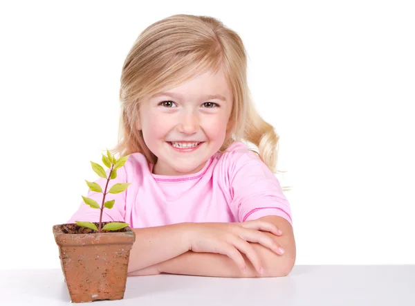 Kind mit Pflanze lächelt — Stockfoto