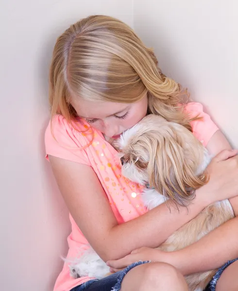 Teen hugging dog in corner — Stock Photo, Image