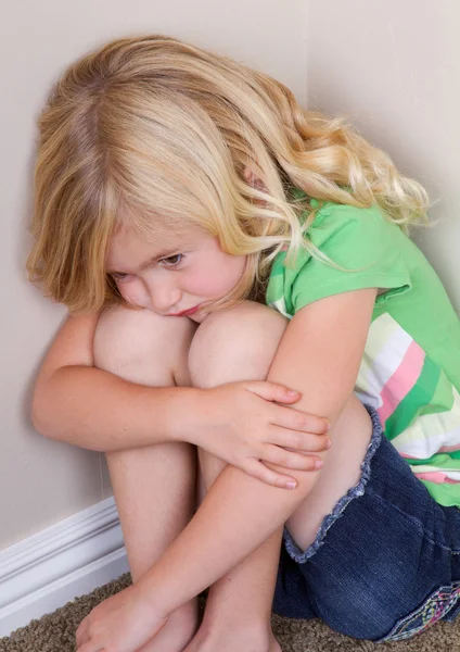 Kind zitten in hoek — Stockfoto