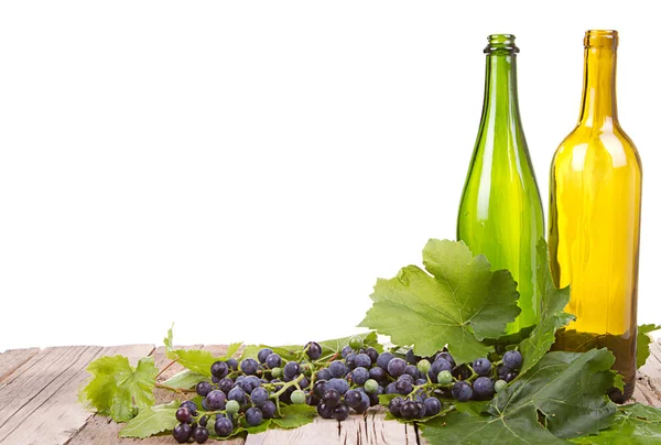 Виноград і пляшки на дерев'яній дошці — стокове фото