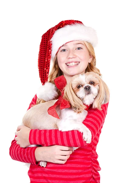 Niño o adolescente sosteniendo un perro con un sombrero de Santa — Foto de Stock