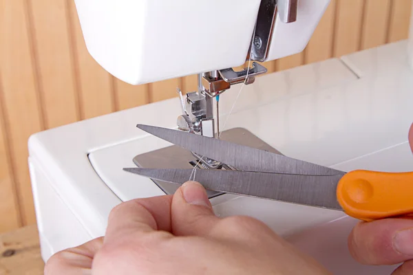 Using scissors to cut thread on sewing machine — Stock Photo, Image