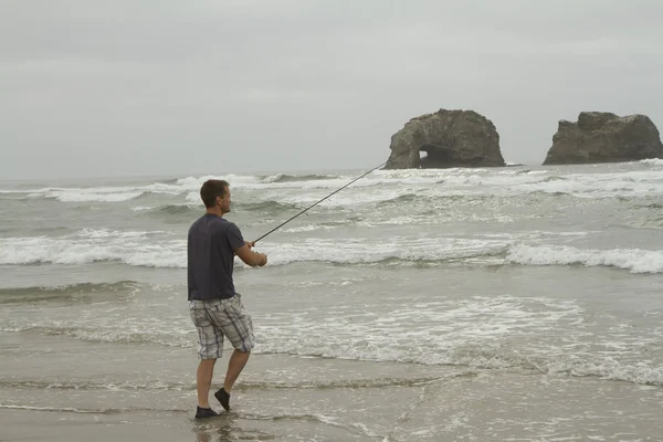 Man fishing in the surf on Rockaway beach — Stock Photo, Image