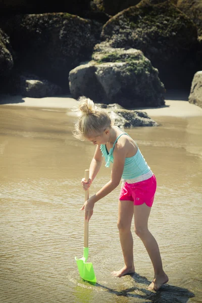 Enfant creusant dans le sable avec une pelle — Photo