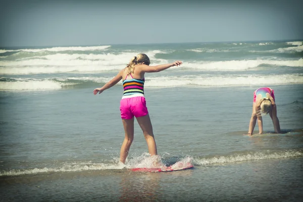 Girl or teen learning to ride a skimboard on the Oregon coast — Stock Photo, Image