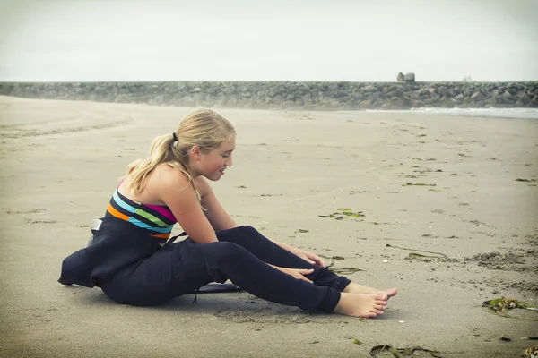 Teen girl putting on a wetsuit at Rockaway Oregon — Stock Photo, Image