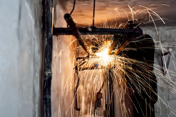 Professionella svetsare skära metalliska rör och slipning stål — Stockfoto