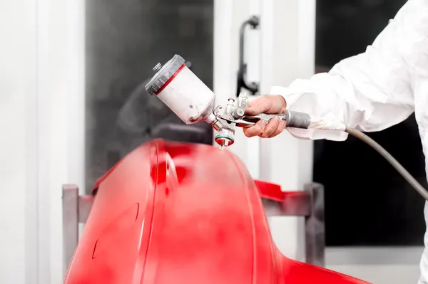 Indústria automobilística - engenheiro trabalhando na pintura de um carro vermelho — Fotografia de Stock