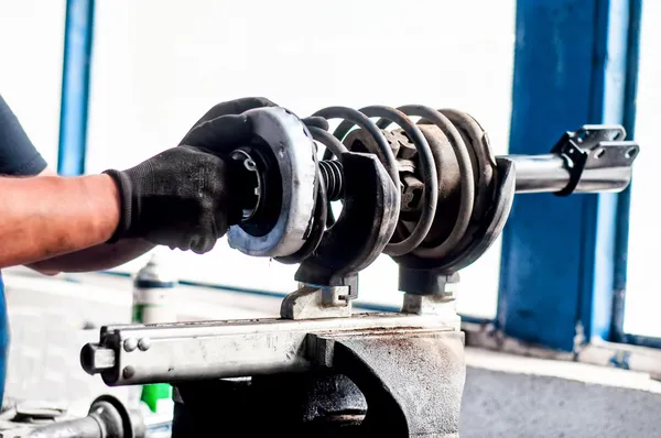 Ingeniero mecánico automático ajustando un amortiguador de coche —  Fotos de Stock