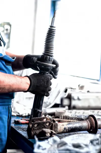 Auto technik mechanik pracuje na auto tlumiče — Stock fotografie