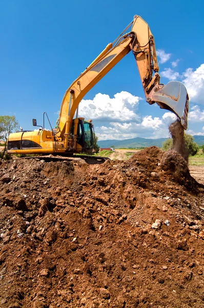 Gul tunga industriella grävmaskin arbetar och lastning sand — Stockfoto