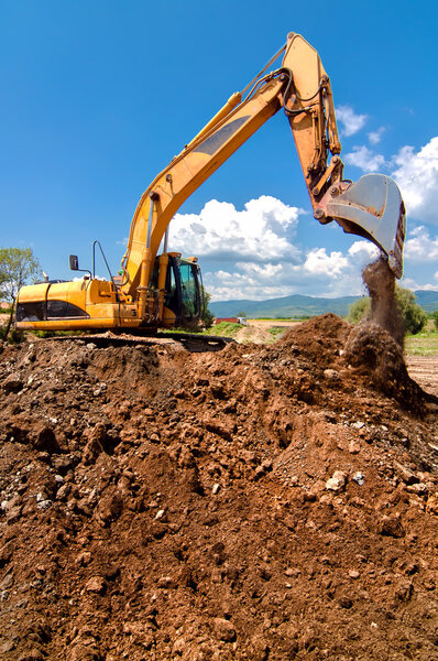 Yellow heavy duty industrial excavator working and loading sand