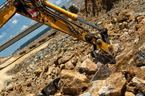 Engenheiro escavadeira movendo areia e rochas com colher de serviço pesado — Fotografia de Stock