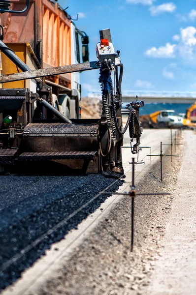 Industrial pavement truck or machine laying fresh bitumen and asphalt — Stock Photo, Image