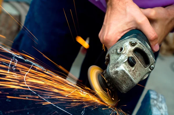 Heavy industry worker cutting steel with angle grinder at car service — Stock Photo, Image