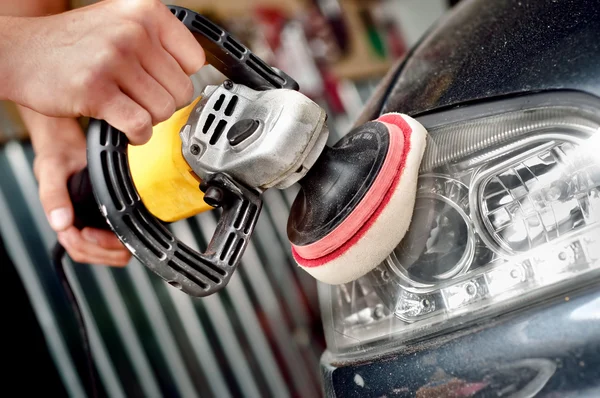 Car headlight cleaning with power buffer machine at service station — Stock Photo, Image