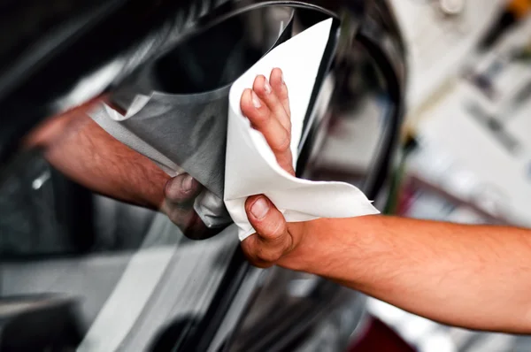 Автомобильный рабочий и механик чистят окна автомобилей — стоковое фото