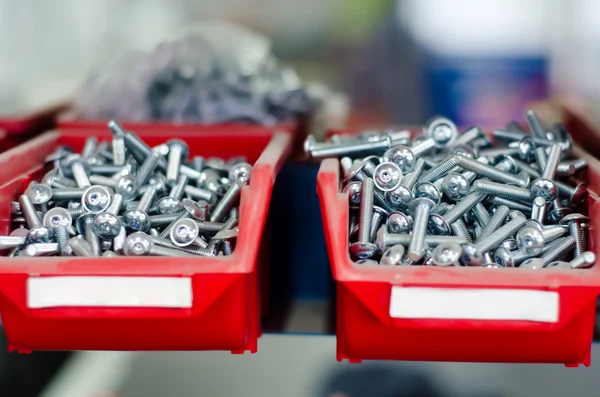 Red cabinets with screws and bolts in a modern factory — Stock Photo, Image