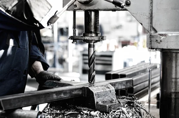 Industrial engineer working on a drilling machine, making a hole — Stock Photo, Image