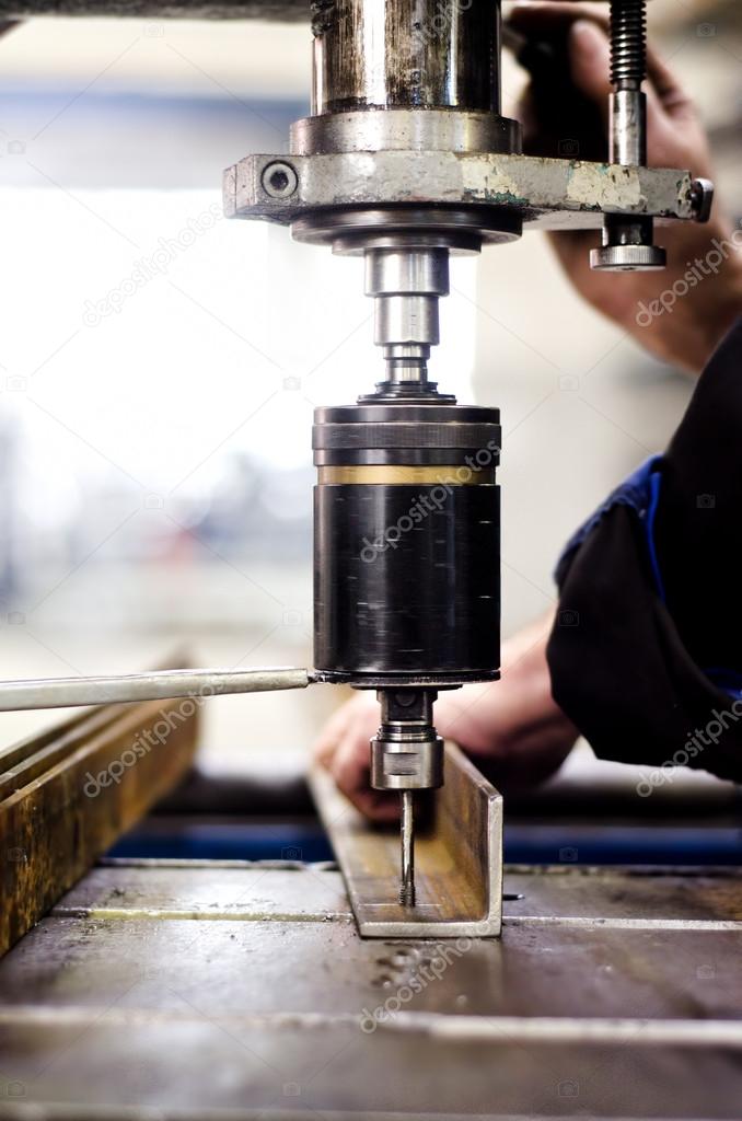 industrial engineer using a mechanical drill machine in a factor