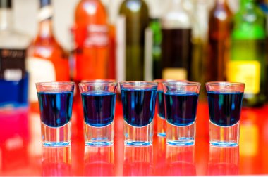 Beş blue curacao alkollü çekim şişe arka plan üzerinde bar