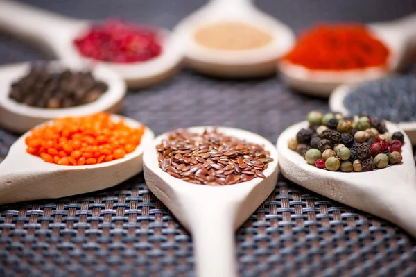 Various kind of spices on wooden spoon - detail of linseed — Stock Photo, Image