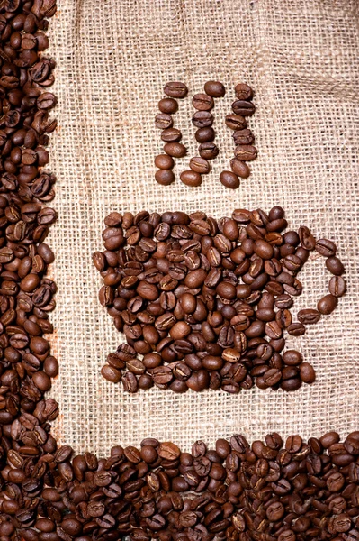 Кофе-бобы кружка на мешок ткани фоне — стоковое фото