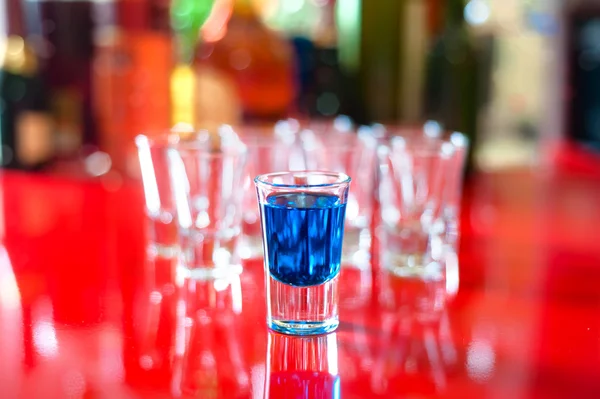 Blue hot alcoholic drink in shot glass on bar — Stock Photo, Image