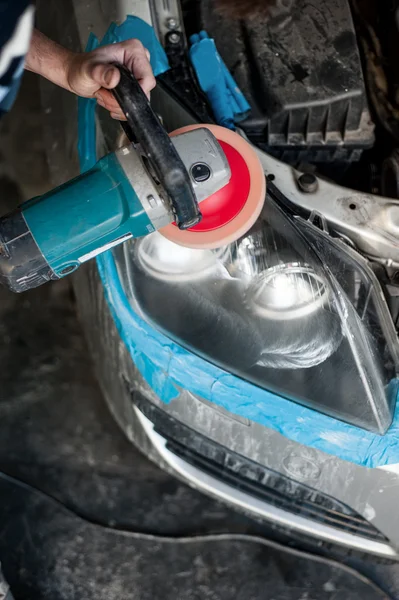 Mechanic cleaning headlights with polishing power buffer machine — Stock Photo, Image