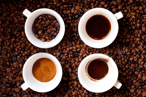 Vier verschillende mokken koffie, grond, koffiebonen, vloeibare koffie en lege mok, geïsoleerd op verse Afrikaanse koffie achtergrond — Stockfoto