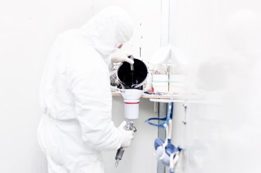 Otomotiv işçisi siyah boya beyaz özel takım giyen bir araba vücut çalışmak için hazırlanıyor.