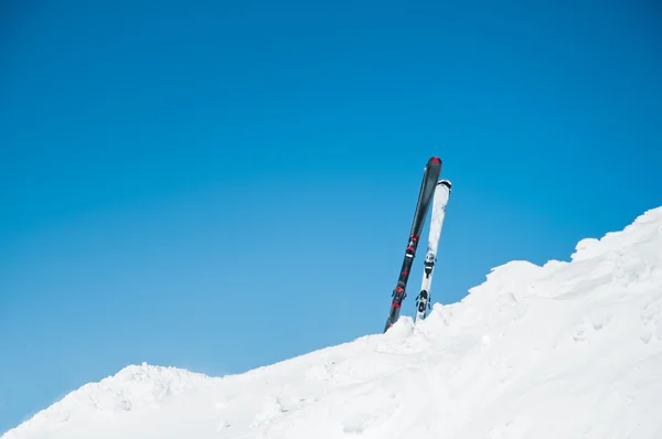 Image of skis on slope, on winter resort with slope background and clear sky — Stock Photo, Image