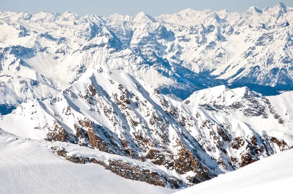 Winterlandschap met lopes op een skigebied in de Alpen met bergen achtergrond — Stockfoto