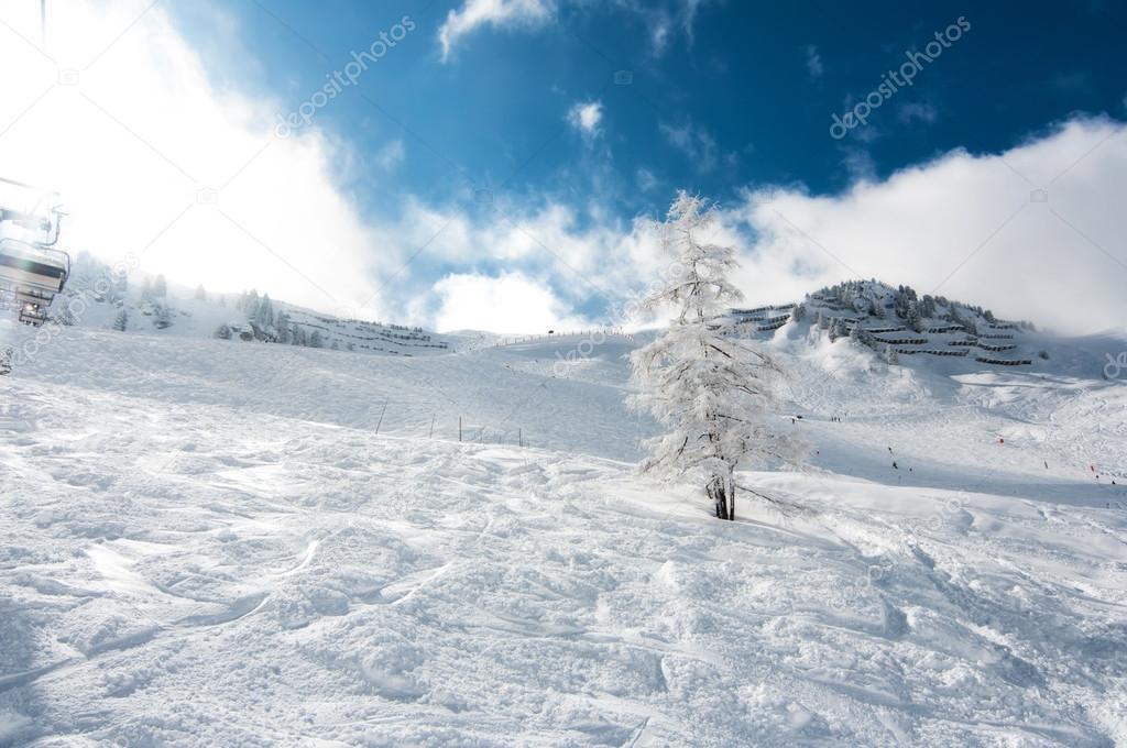 Dreamy sunny landscape in Austrian Alps during winter, in remote ski area with blue sky and powder snow everywhere