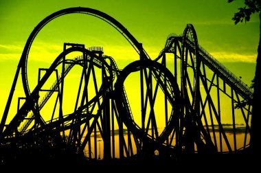 Silhouette of a roller coaster at sunset, after a sunny day