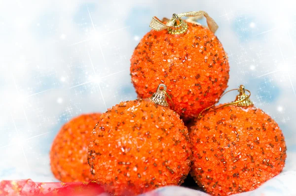 Cuatro bolas de Navidad brillantes de color naranja con fondo brillante de copos de nieve —  Fotos de Stock