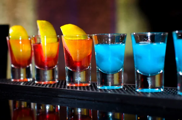 Several alcoholic shots of diferent drinks at a party in a nightclub on the counter — Stock Photo, Image