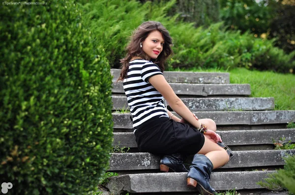 Fashion Girl sitting on stairs in park — Stock Photo, Image