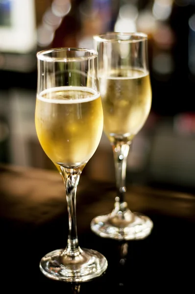 Two champagne or wine glasses against bar background — Stock Photo, Image