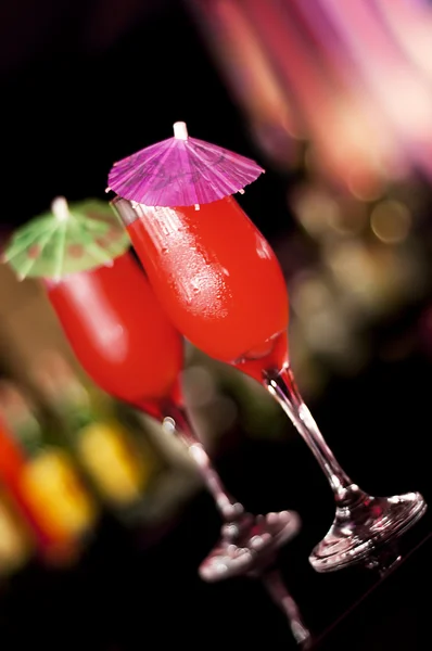 Two fancy red cocktails with alcoholic beverage and little decorative umbrellas — Stock Photo, Image